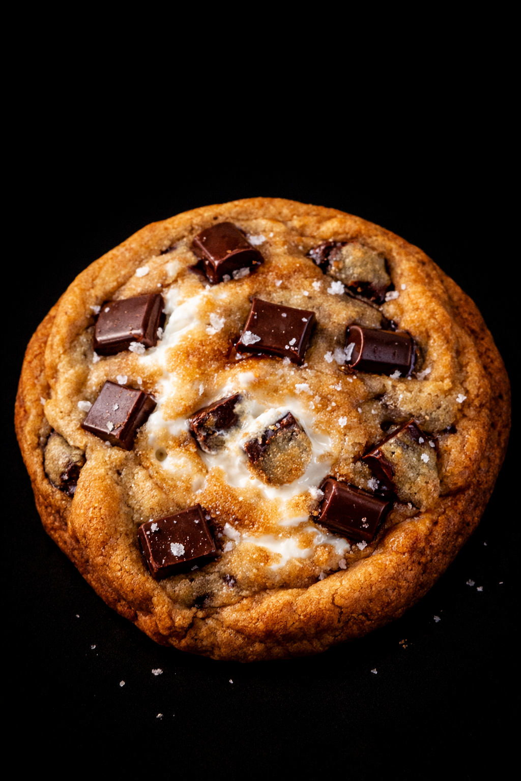 Chocolate chip cookie with marshmallows on a black background